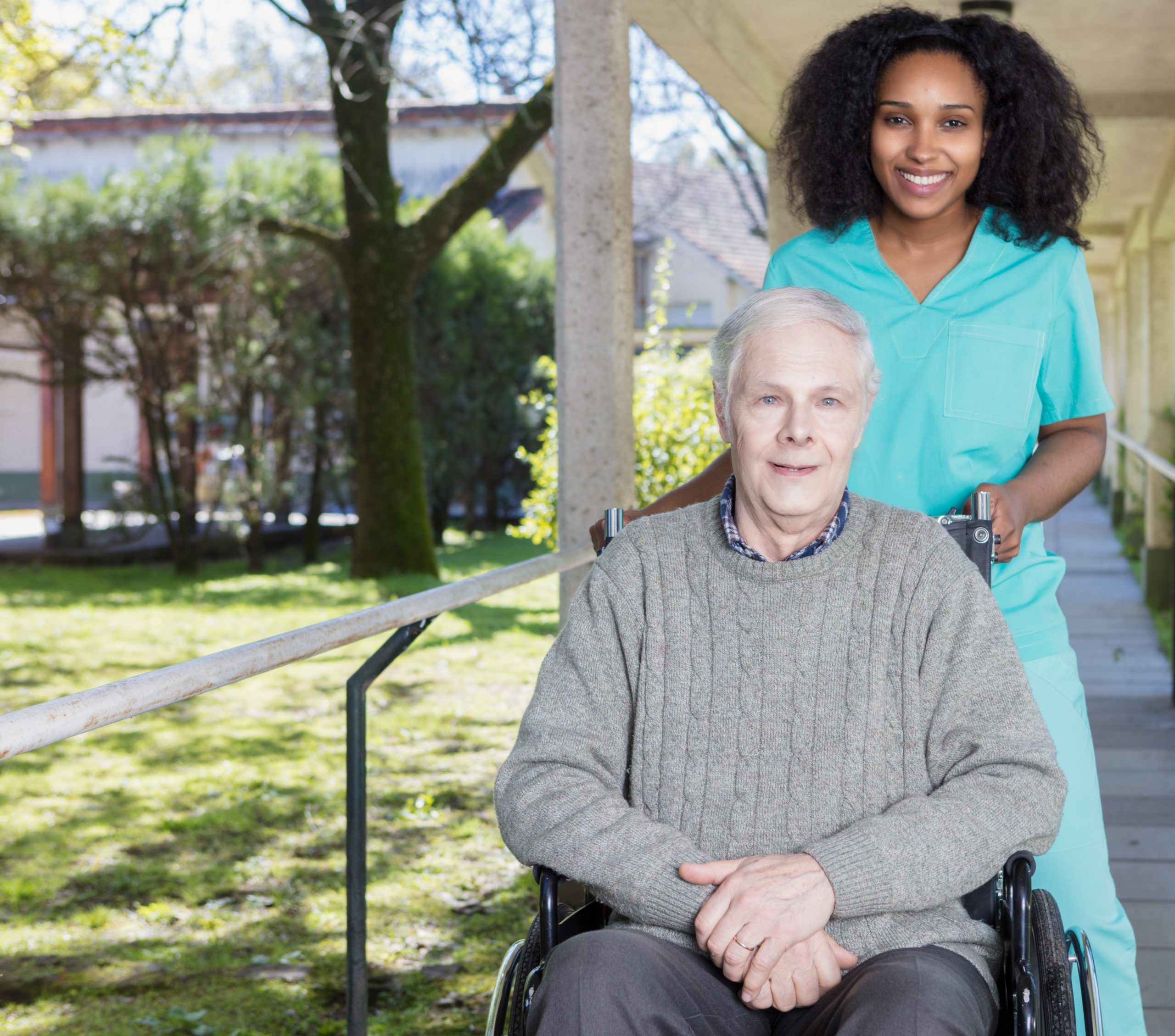 African nurse helping man on the wheelchair.