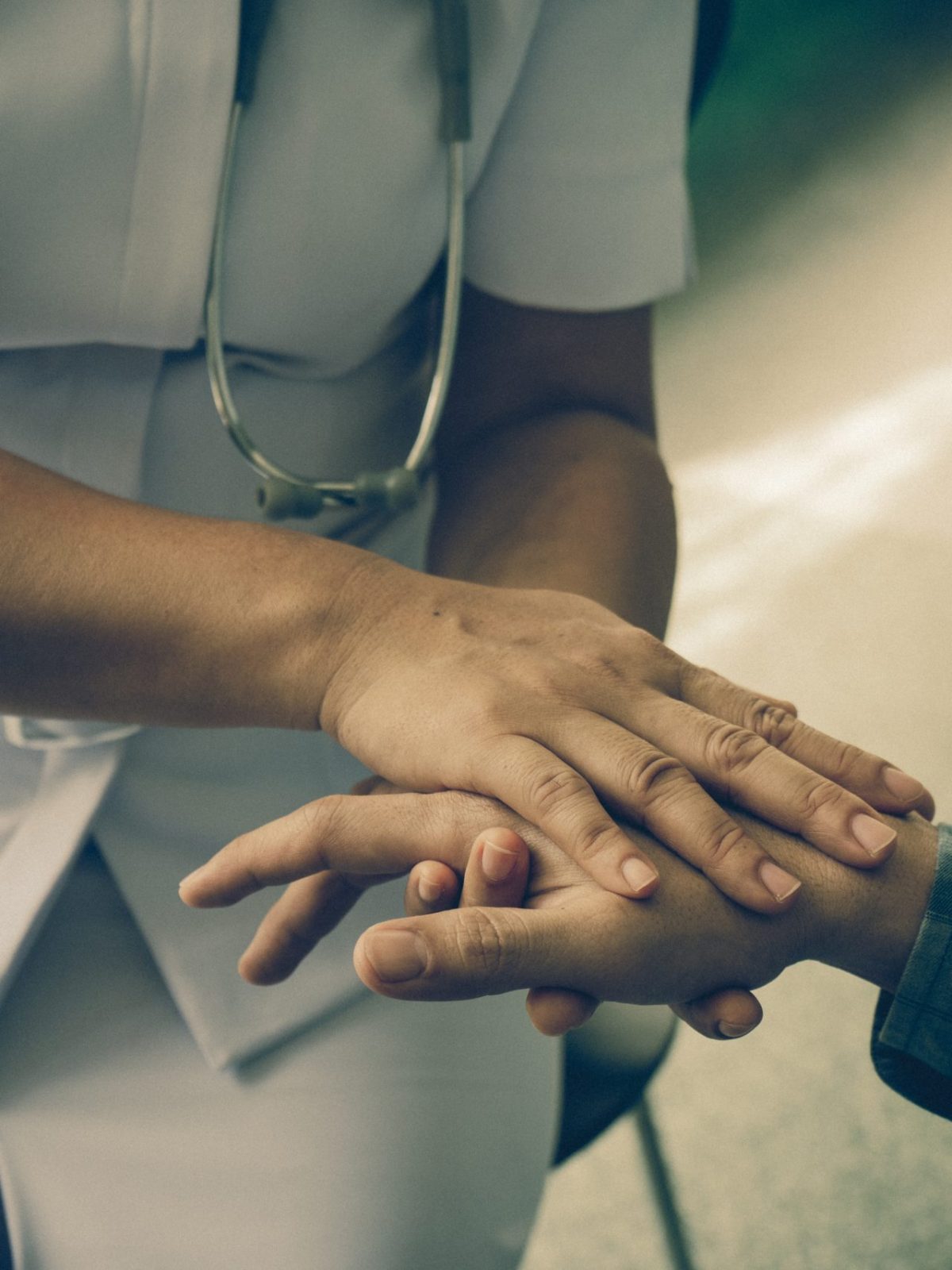 Nurse holding the hand of a patient man, showing sympathy and kindness, vintage style